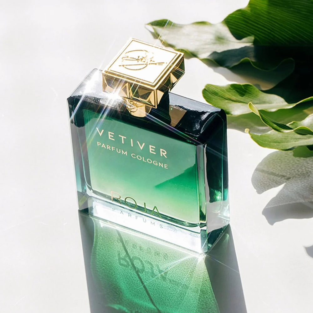 Green parfum cologne bottle with gold cap on a white background